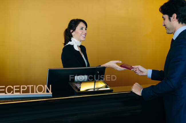 Businessman checking in at hotel reception — Stock Photo