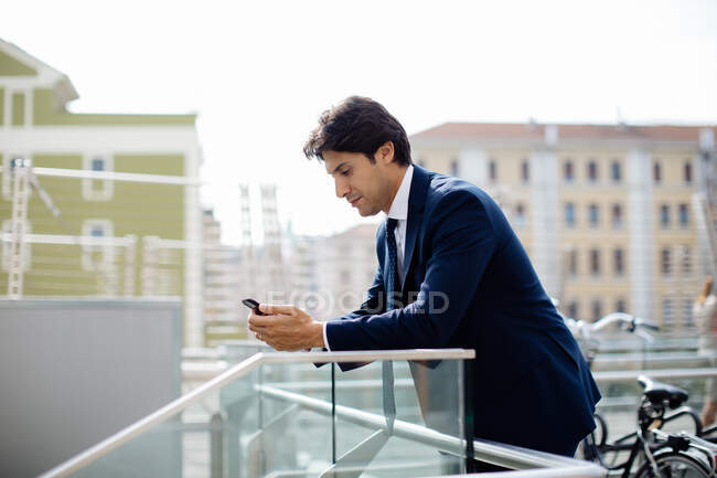 Бизнесмен с помощью смартфона на террасе — стоковое фото