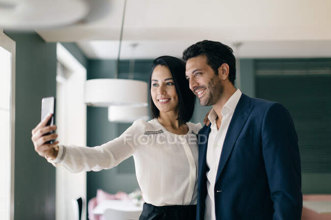 Couple in hotel taking smartphone selfie — Stock Photo