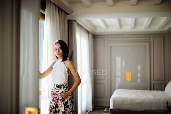 Donna alla moda accanto alla finestra in suite — Foto stock