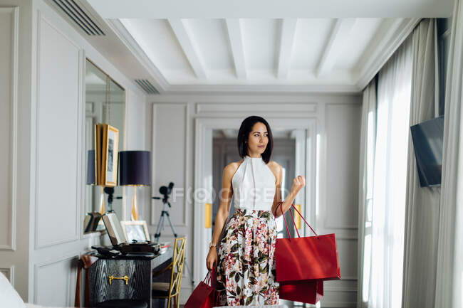 Mulher elegante com sacos de compras em suite — Fotografia de Stock