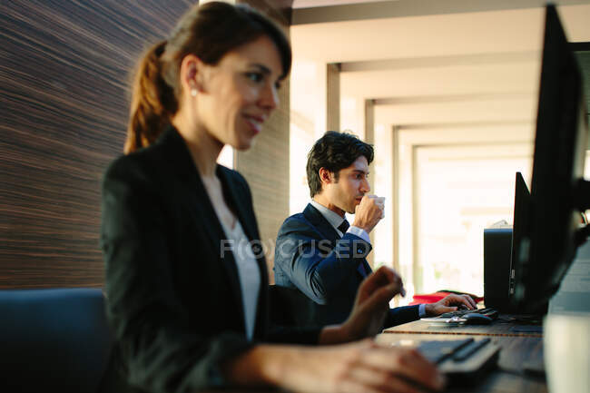 Businessman and businesswoman working in business centre in hotel — Stock Photo