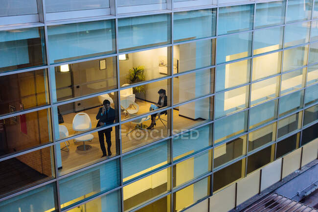 Businessman and businesswoman having discussion by window — Stock Photo