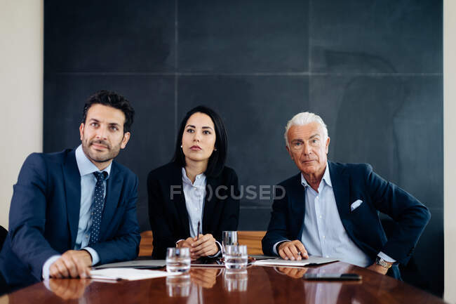 Geschäftsleute und Frauen am Vorstandstisch lauschen Präsentation — Stockfoto