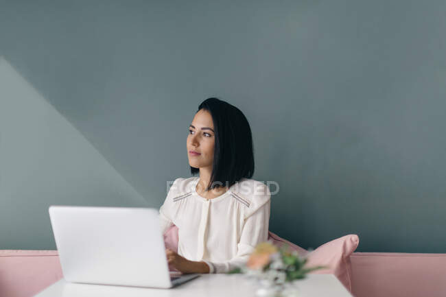 Young businesswoman at hotel table daydreaming — Stock Photo