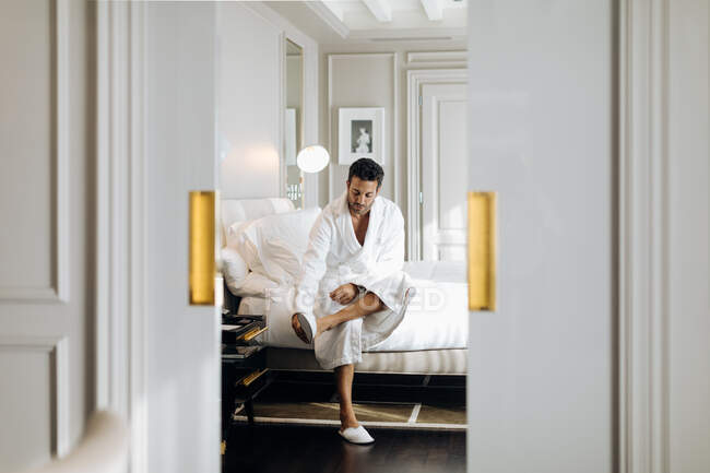 Mann trägt Schlafzimmerpantoffel in Suite — Stockfoto