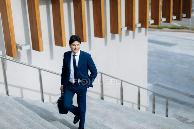 Businessman walking up stairway — Stock Photo