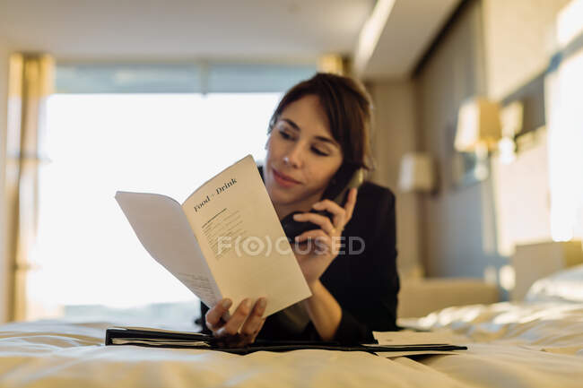 Donna d'affari che ordina il servizio in camera in hotel — Foto stock