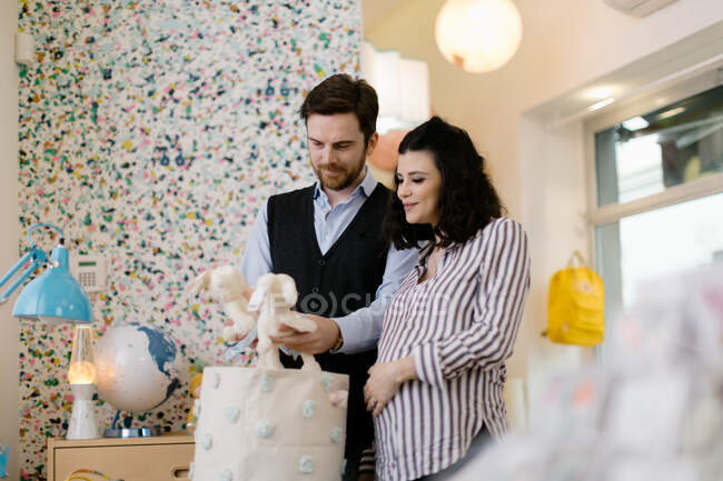 Mari et femme enceinte faisant du shopping pour des jouets mous — Photo de stock