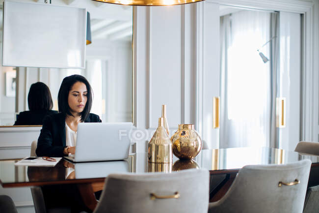 Businesswoman using laptop in suite — Stock Photo