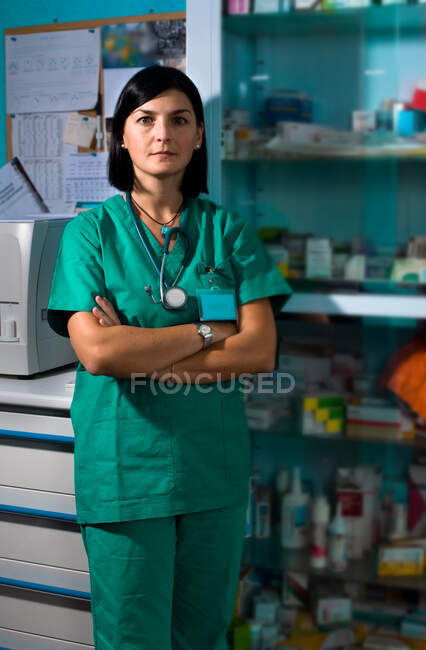 Portrait of female surgeon wearing scrubs standing in operating theatre. — Stock Photo