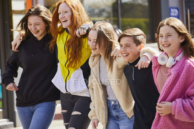 Grupo de meninas adolescentes e menino andando lado a lado ao ar livre. — Fotografia de Stock