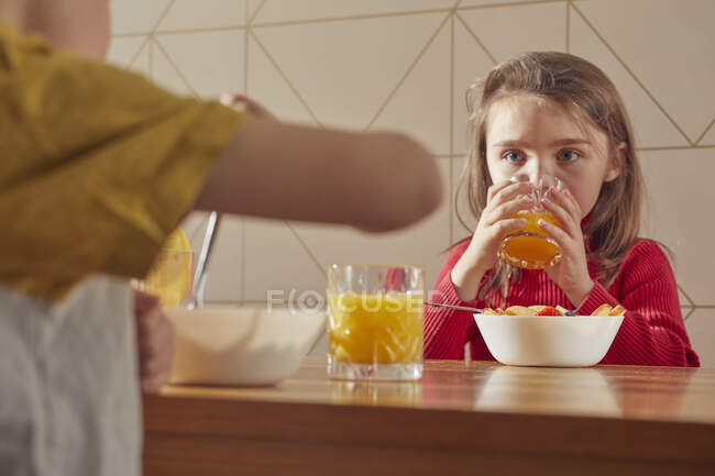 Хлопчик і дівчинка сидять за кухонним столом і снідають.. — стокове фото