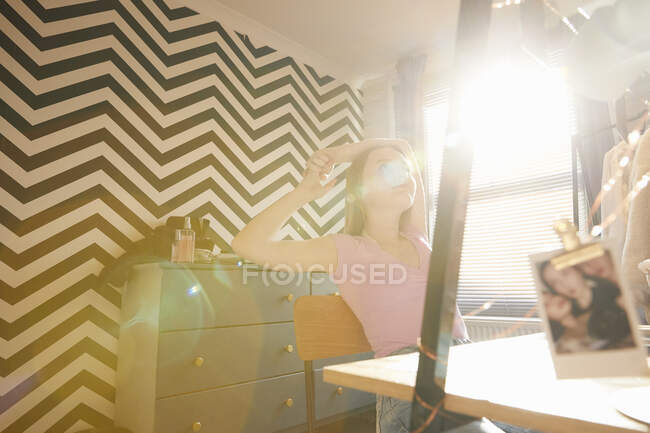 Ragazza adolescente seduta nella sua stanza a una scrivania, sognando ad occhi aperti. — Foto stock