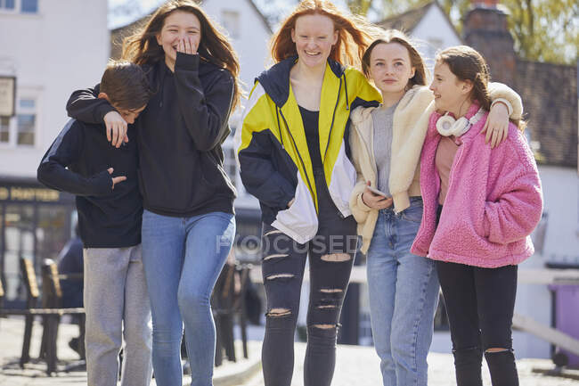 Группа девочек-подростков и мальчиков, идущих бок о бок на открытом воздухе. — стоковое фото