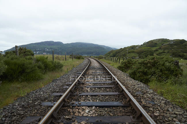 Vista ao longo de uma trilha ferroviária no País de Gales rural em um dia nublado — Fotografia de Stock