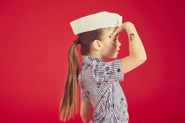 Linda chica morena con sombrero marinero y posando, mirando hacia otro lado - foto de stock