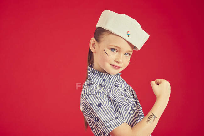 Happy smiling brunette girl wearing sailor hat and posing on camera — Stock Photo