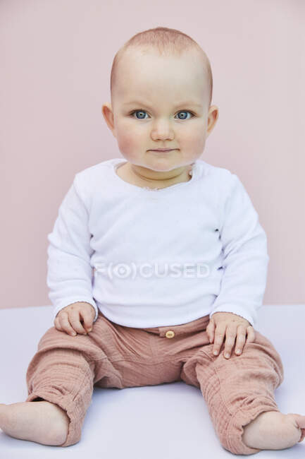 Portrait of baby girl on pink background. — Stock Photo