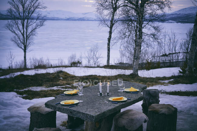 Mesa ao ar livre com pratos, copos de vinho e velas em Vasterbottens Lan, Suécia. — Fotografia de Stock