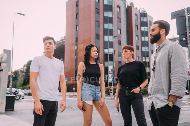 Two young women and men wearing casual clothes standing on urban street. — Stock Photo