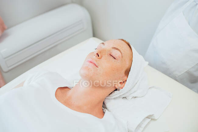 Frau liegt auf Behandlungsbett in Schönheitssalon. — Stockfoto
