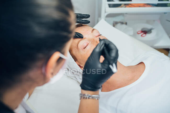 Mujer haciendo sus cejas en un salón de belleza. - foto de stock