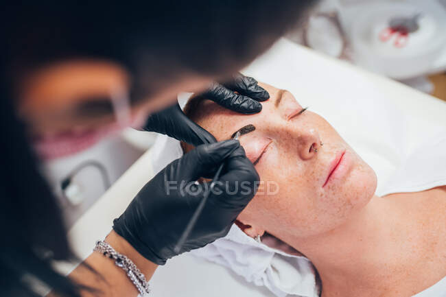 Mulher recebendo suas sobrancelhas feitas em um salão de beleza. — Fotografia de Stock