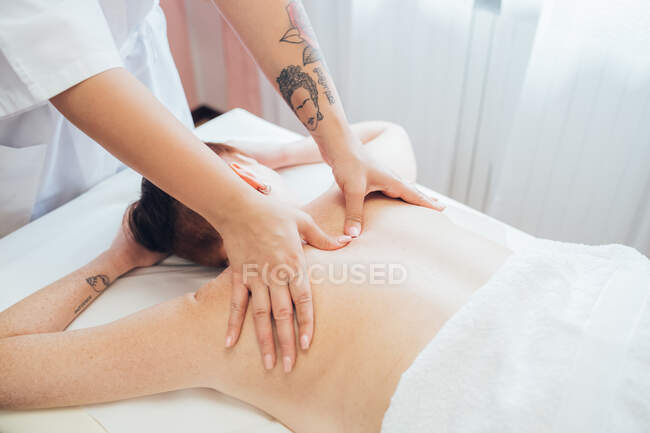 Donna ottenere un massaggio alla schiena in un salone di bellezza. — Foto stock