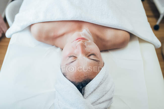 Женщина лежит на кровати в салоне красоты. — стоковое фото