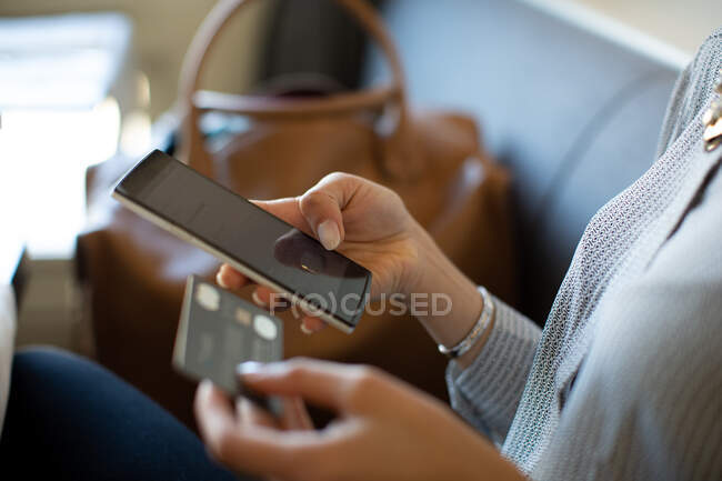 Close up of woman holding credit card and mobile phone. — Stock Photo