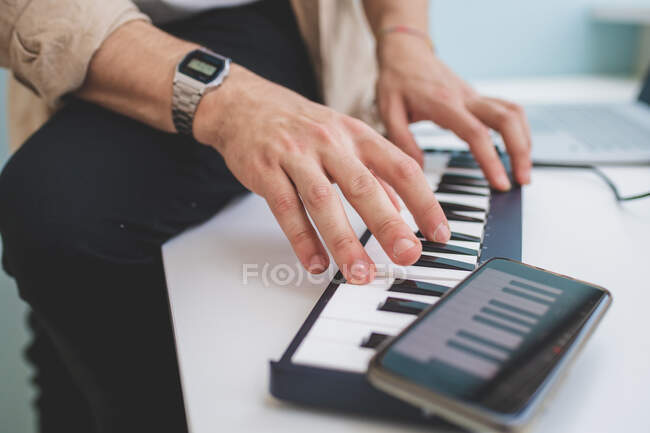 Gros plan des mains de l'homme jouant sur la musique du clavier — Photo de stock