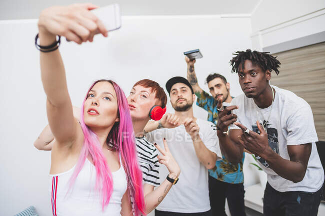 Amici che scattano selfie sul cellulare in camera — Foto stock