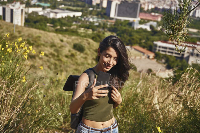 Bela morena mulher tomando uma selfie na natureza — Fotografia de Stock