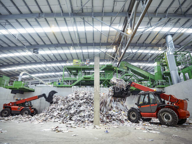 Diggers with waste paper in waste recycling plant. — Stock Photo