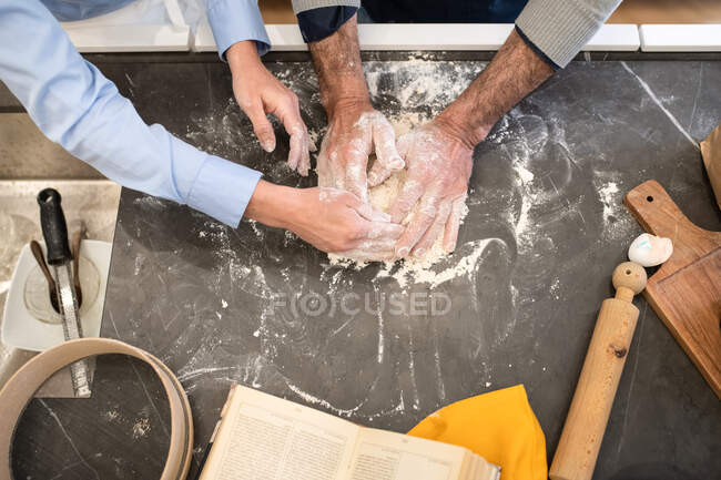 Couple standing in a kitchen, making fresh homemade pasta. — Stock Photo