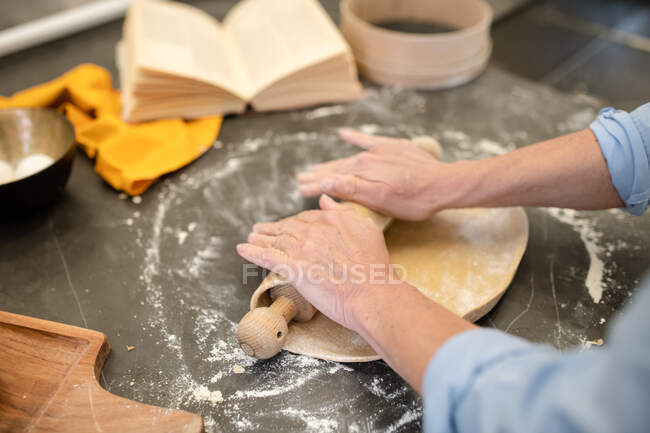 Pareja de pie en una cocina, haciendo pasta fresca casera. - foto de stock