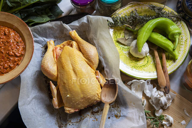 Alto angolo di primo piano di pollo ruspante, peperoni, aglio ed erbe aromatiche. — Foto stock