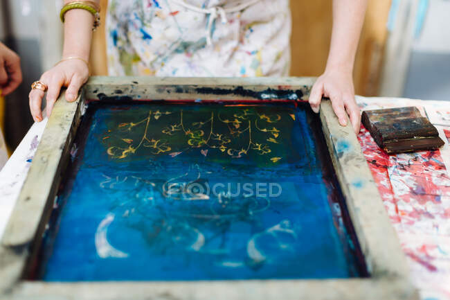 Woman doing silk screen print in creative studio, mid section, close-up — Stock Photo