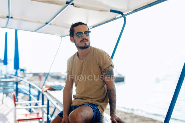 Homem relaxante sob dossel no mar, Livorno, Itália — Fotografia de Stock