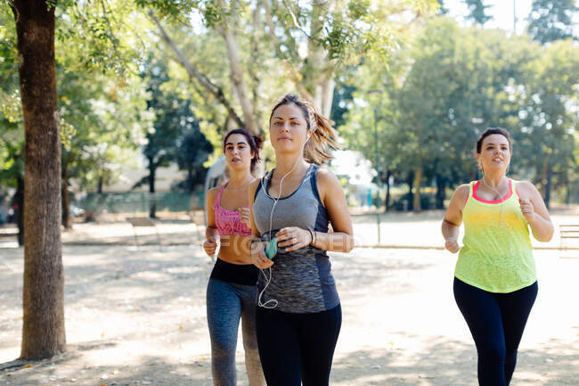 Tre amici che fanno jogging nel parco — Foto stock