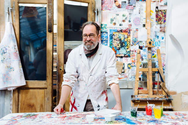 Портрет мужчины-художника в творческой мастерской, улыбающийся — стоковое фото