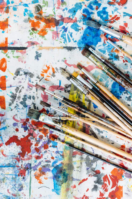 Bodegón de pinceles en la superficie pintada de colores, vista aérea - foto de stock