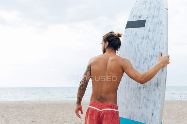 Surfista com prancha à beira-mar — Fotografia de Stock