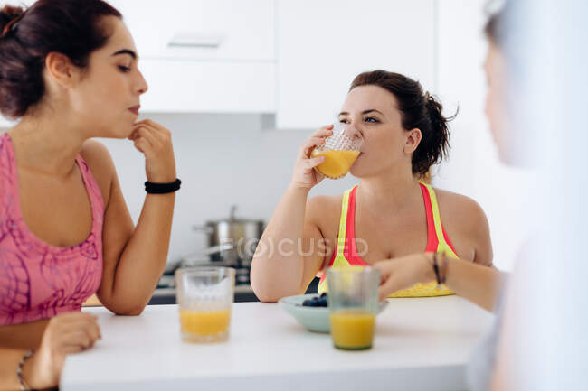 Amici che si godono il succo a casa dopo l'esercizio — Foto stock
