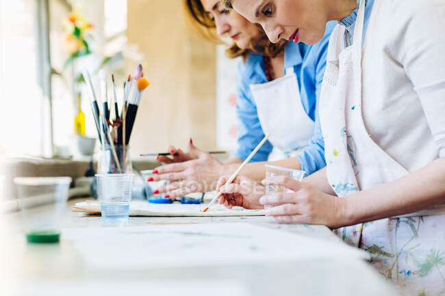 Две женщины рисуют в творческой студии — стоковое фото