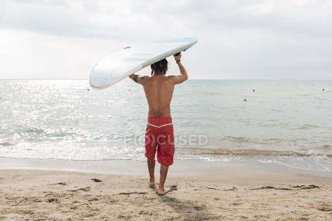 Surfista con tavola da surf al mare — Foto stock