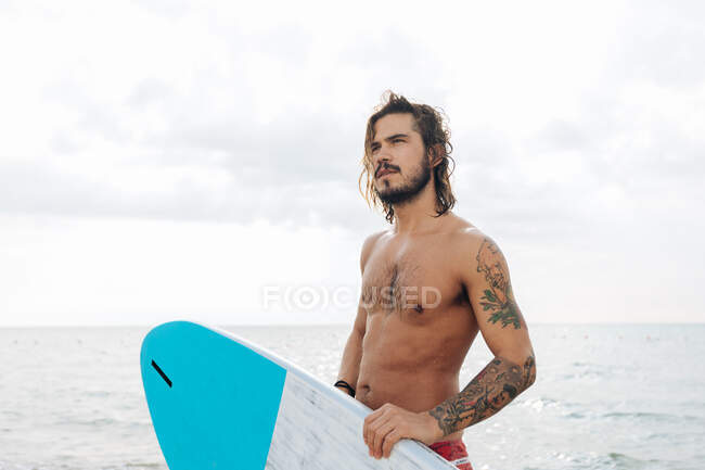 Серфер з дошкою для серфінгу на морі — стокове фото