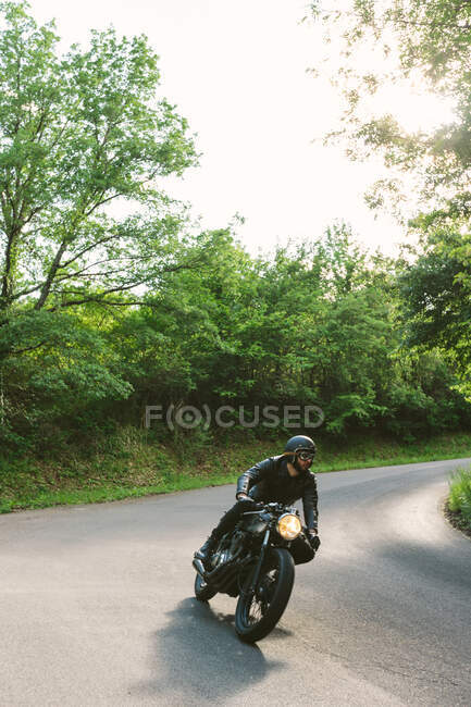 Junger männlicher Motorradfahrer auf Oldtimer-Motorrad auf Landstraße Kurve, Florenz, Toskana, Italien — Stockfoto