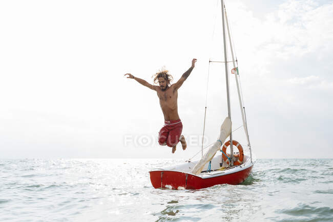Homme sautant du voilier — Photo de stock